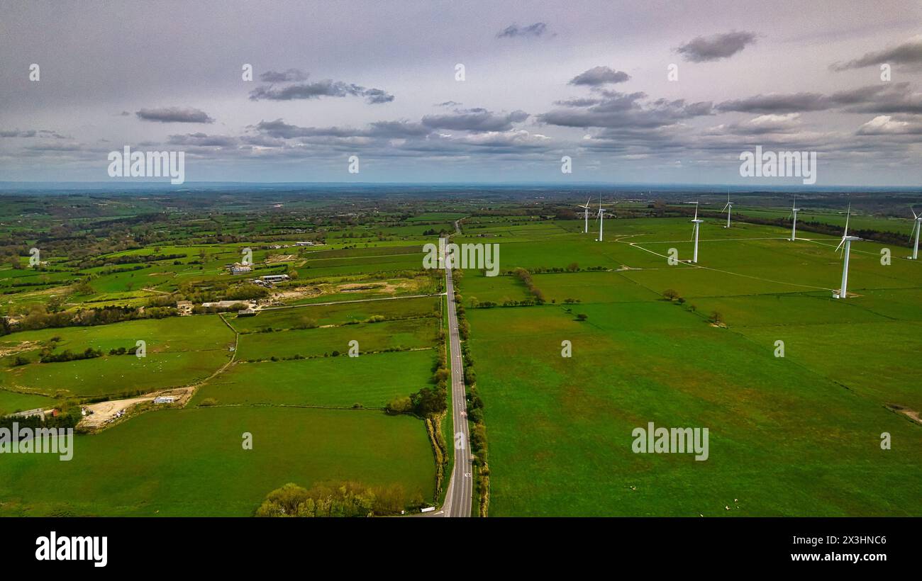 Aerial view of a lush green landscape with wind turbines and a road ...
