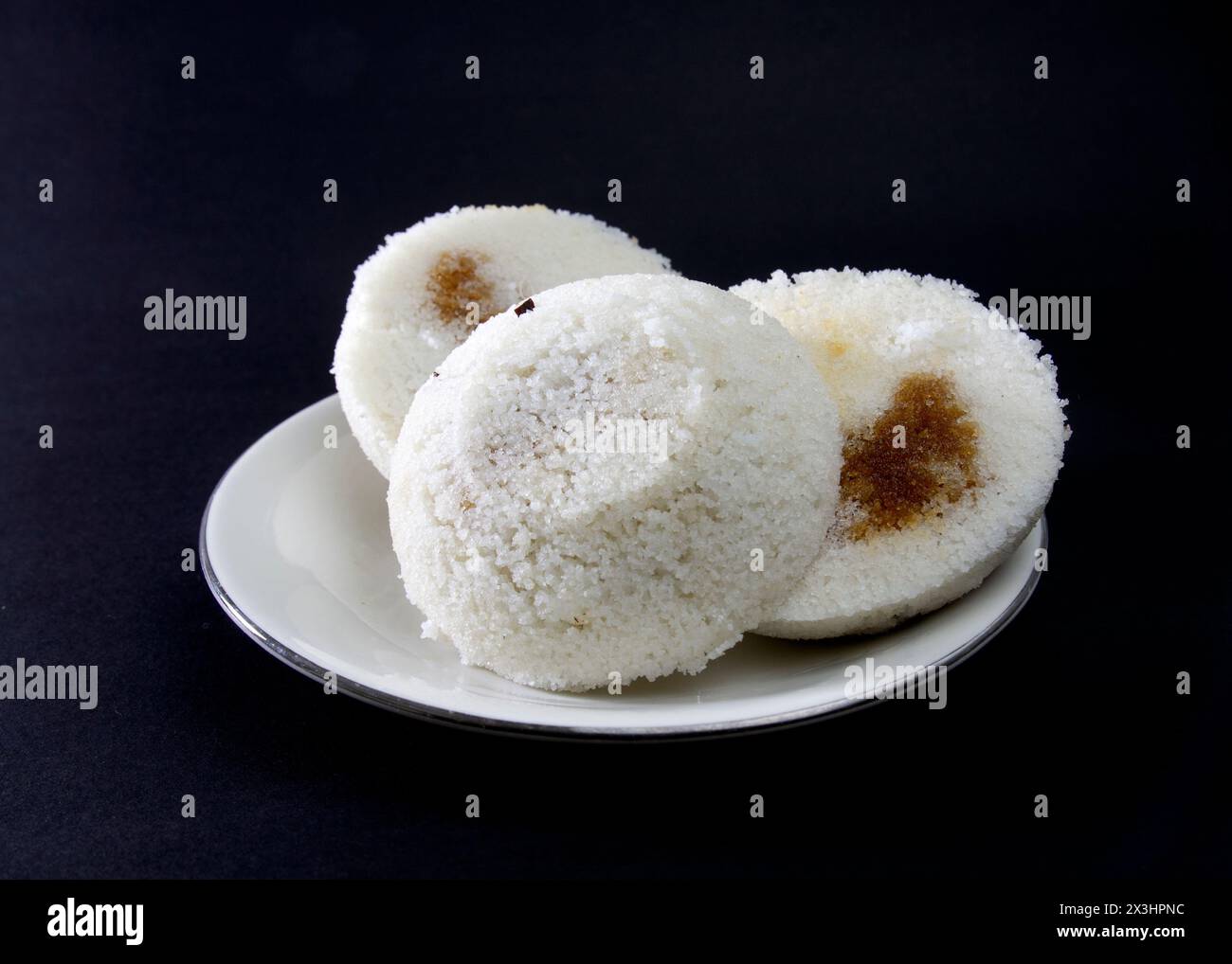 Steamed Rice Cake or Bhapa Pitha is a traditional dish of Bangladesh. Winter rice cake on Black Background. bite or broken pitha. Ingredients are rice Stock Photo