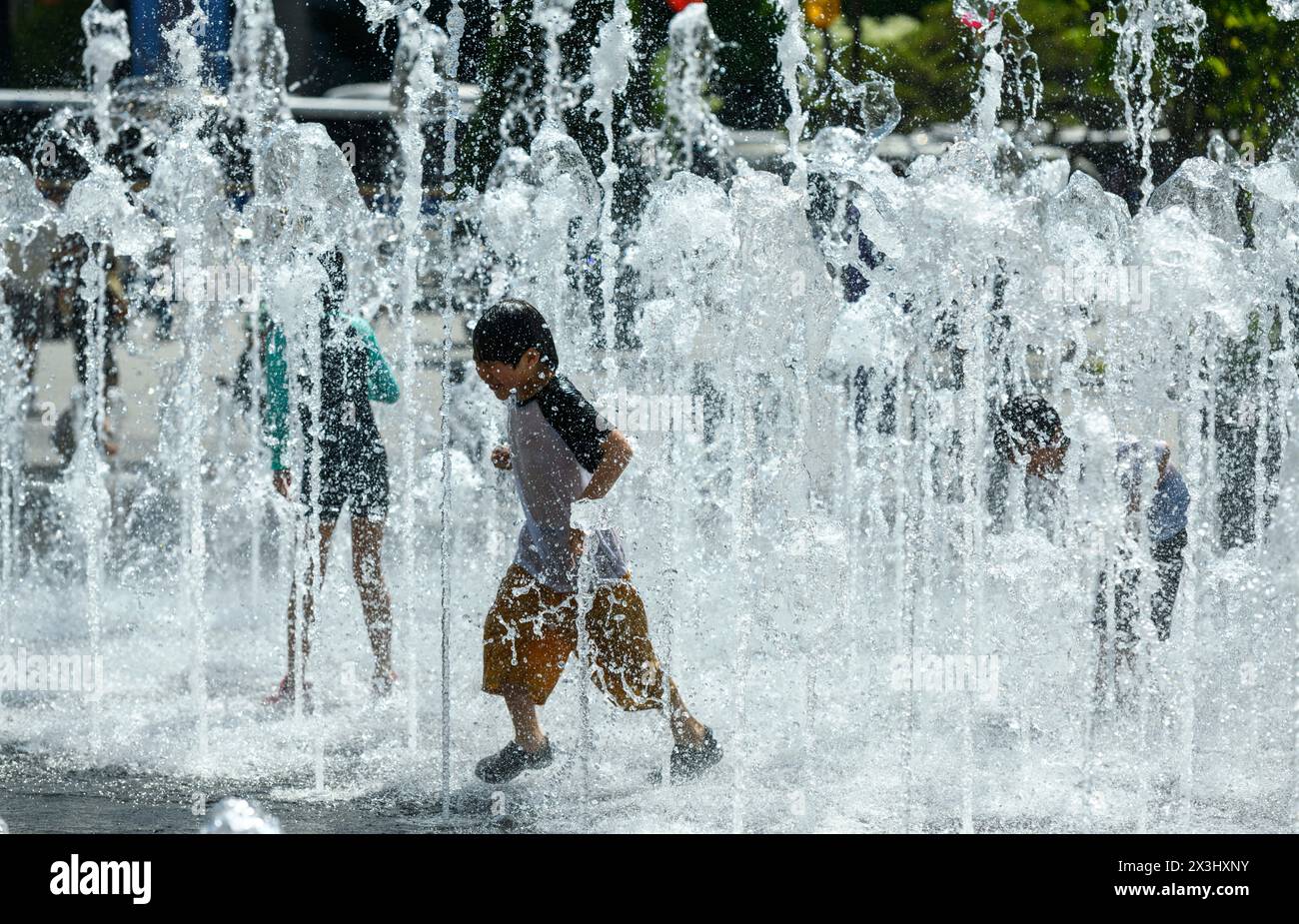 Seoul, South Korea. 27th Apr, 2024. South Korean children play with water at the fountain in the high temperature afternoon at Gwanghwamun Square in Seoul. On April 27, the temperature in Seoul is up to 26 degrees Celsius. (Photo by Kim Jae-Hwan/SOPA Images/Sipa USA) Credit: Sipa USA/Alamy Live News Stock Photo