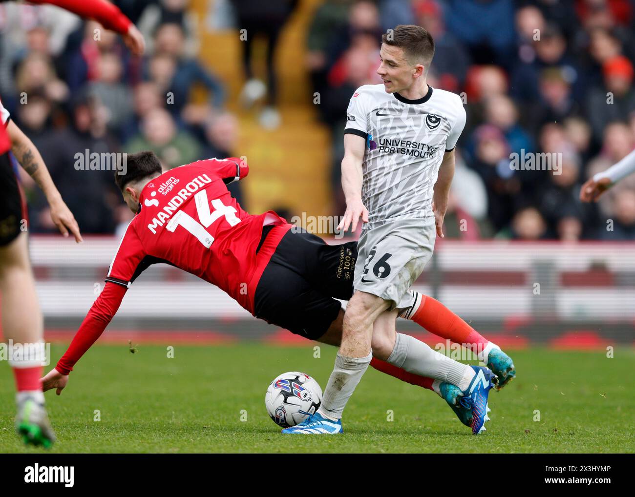 Portsmouth's Tom Lowery fouls Lincoln City's Daniel Mandroiu and Lincoln awarded a penalty during the Sky Bet League One match at the LNER Stadium, Lincoln. Picture date: Saturday April 27, 2024. Stock Photo