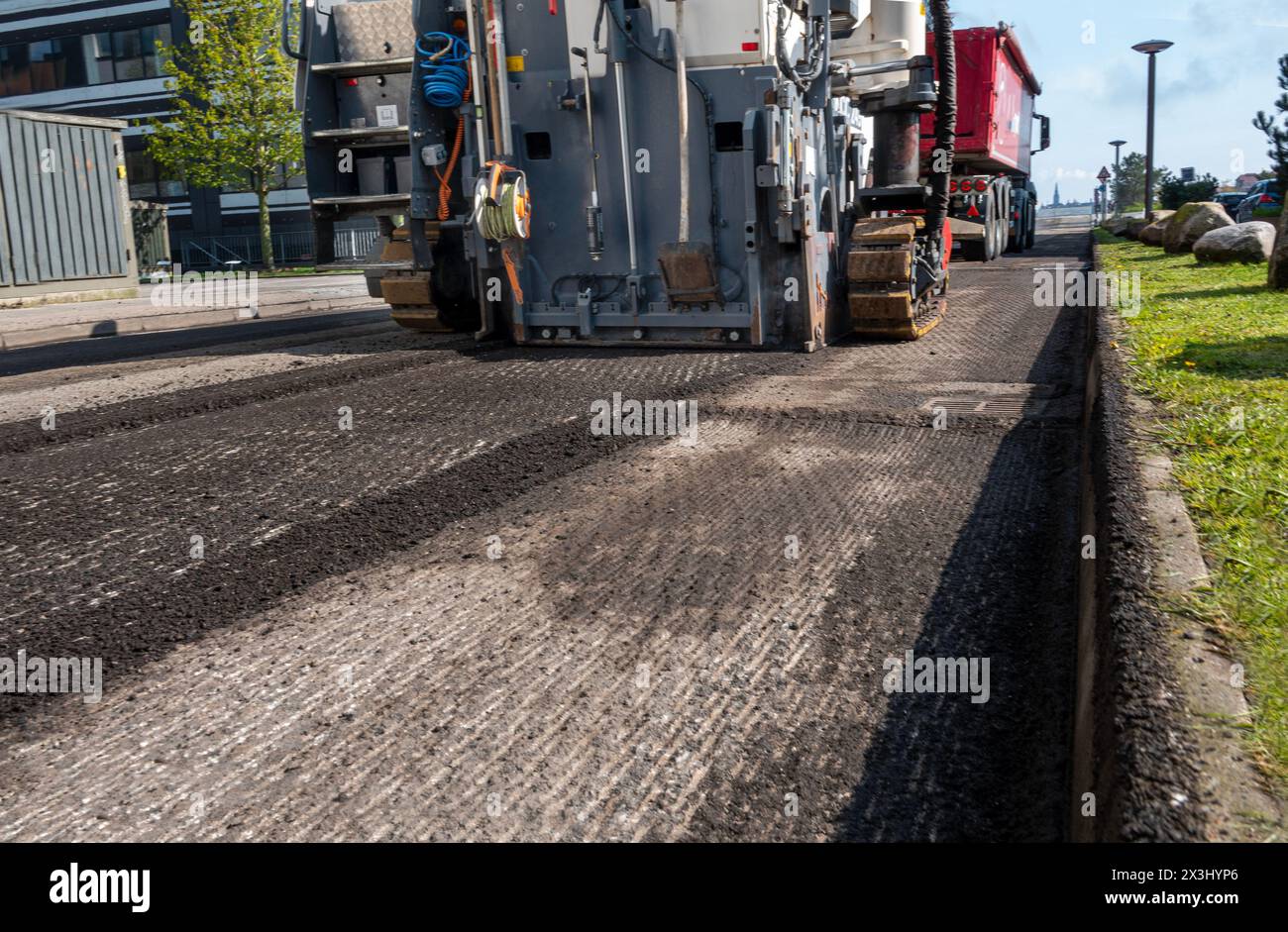 Asphalt milling and grinding scraper machine at road repair. Street renewal with heavy machinery equipment. Stock Photo