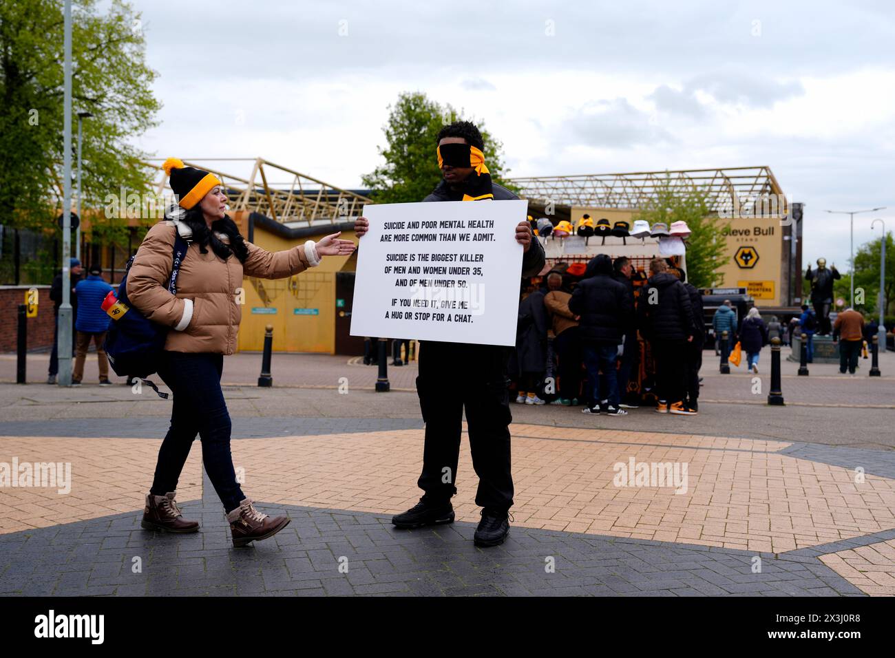 A person holds a sign encouraging people to stop for a chat outside the stadium ahead of the Premier League match at Molineux Stadium, Wolverhampton. Picture date: Saturday April 27, 2024. Stock Photo