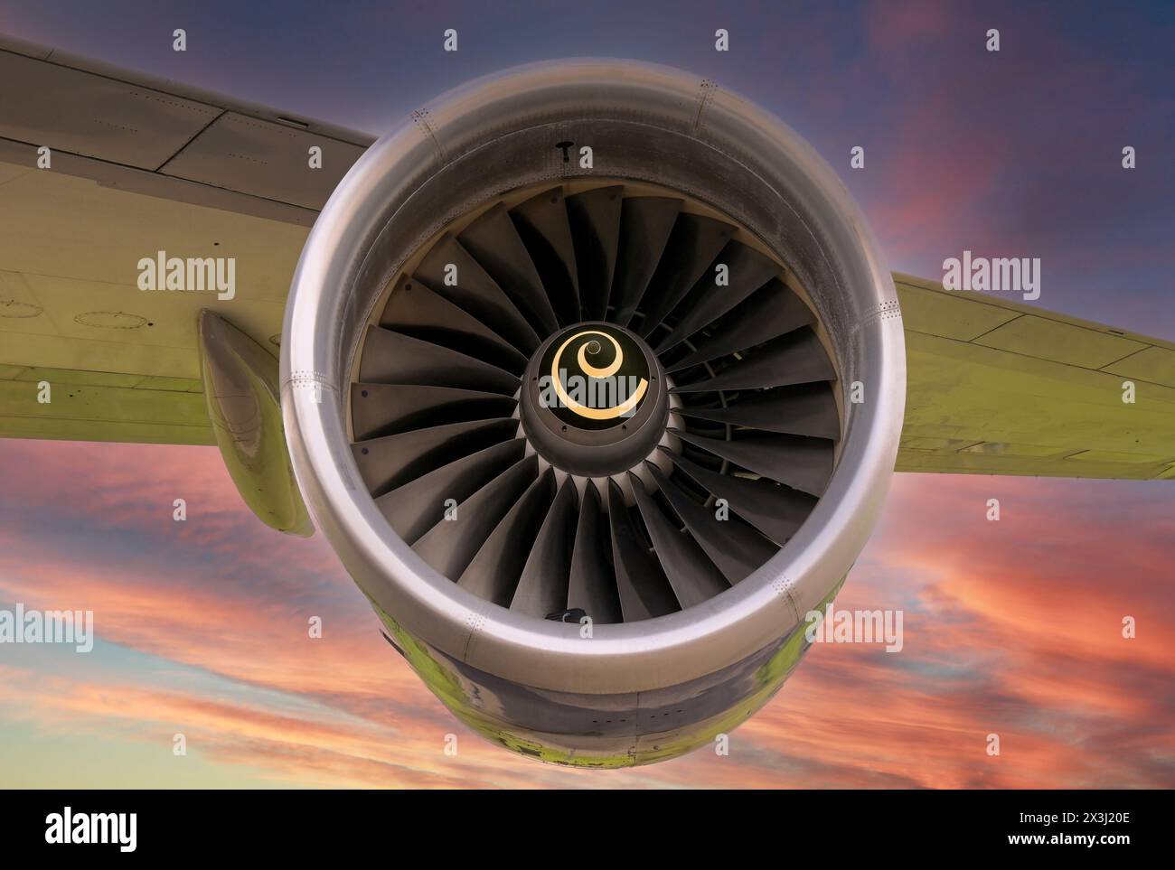 Close up view of a turbofan jet engine on an aircraft wing isolated against a colourful sunset sky. Travel concept. Stock Photo