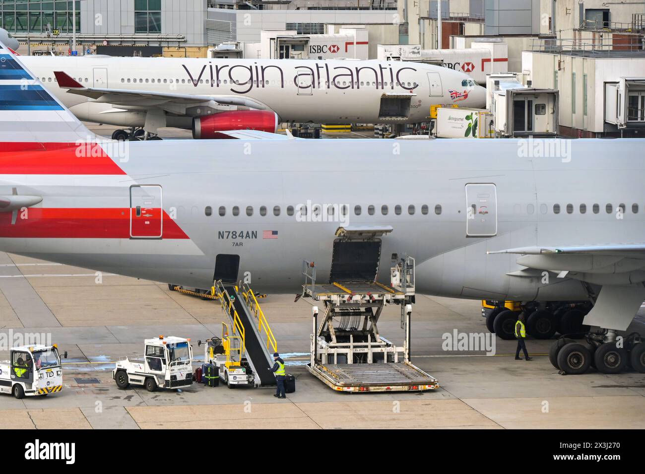 london, England, UK - 29 November 2023: Specialist loading equipment for luggage and cargo alongside an American Airlines jet at London Heathrow airpo Stock Photo