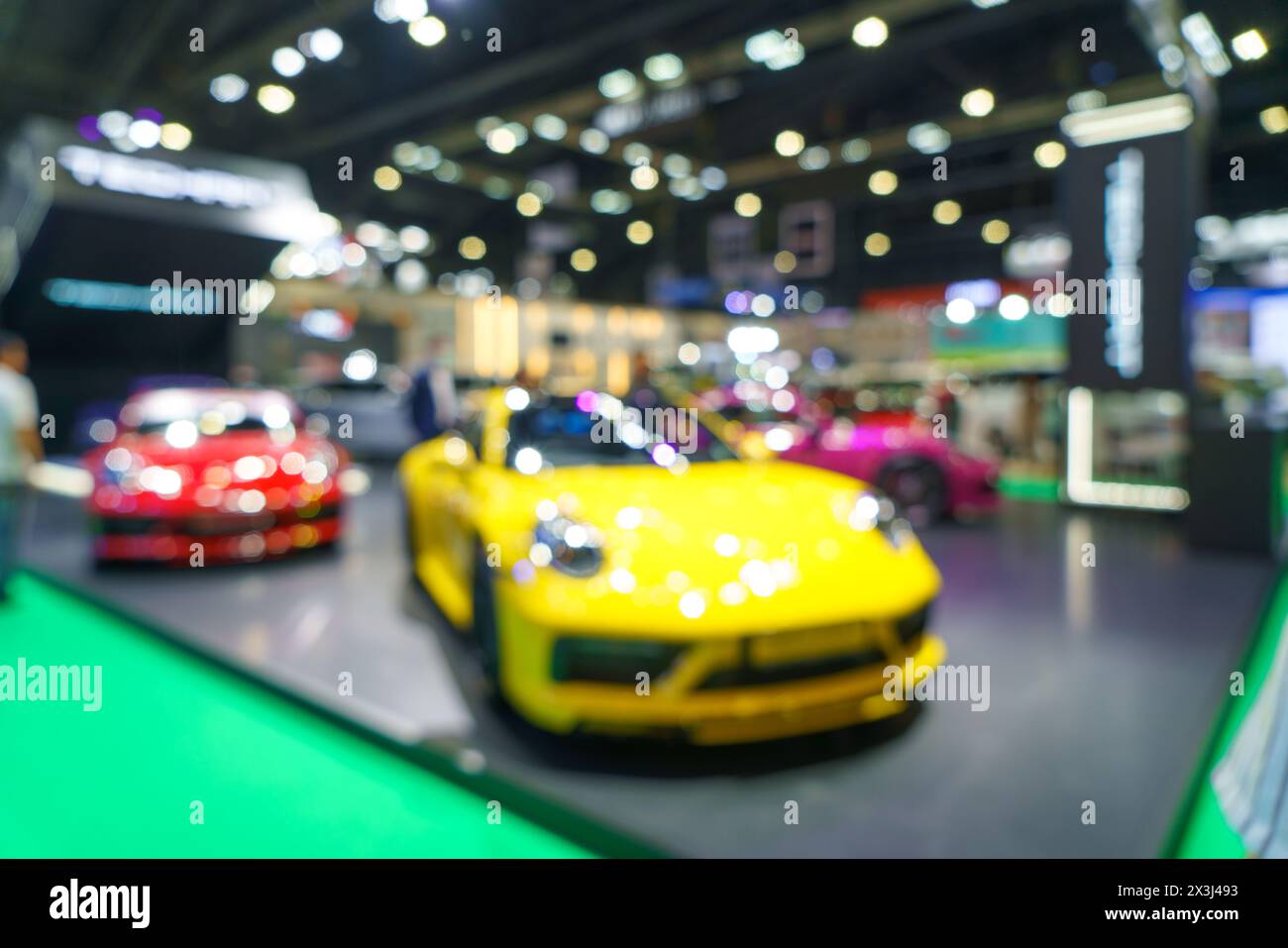 A modern car showroom. The soft focus highlights the sleek lines and vibrant colors of the displayed vehicles, making it an ideal background for autom Stock Photo