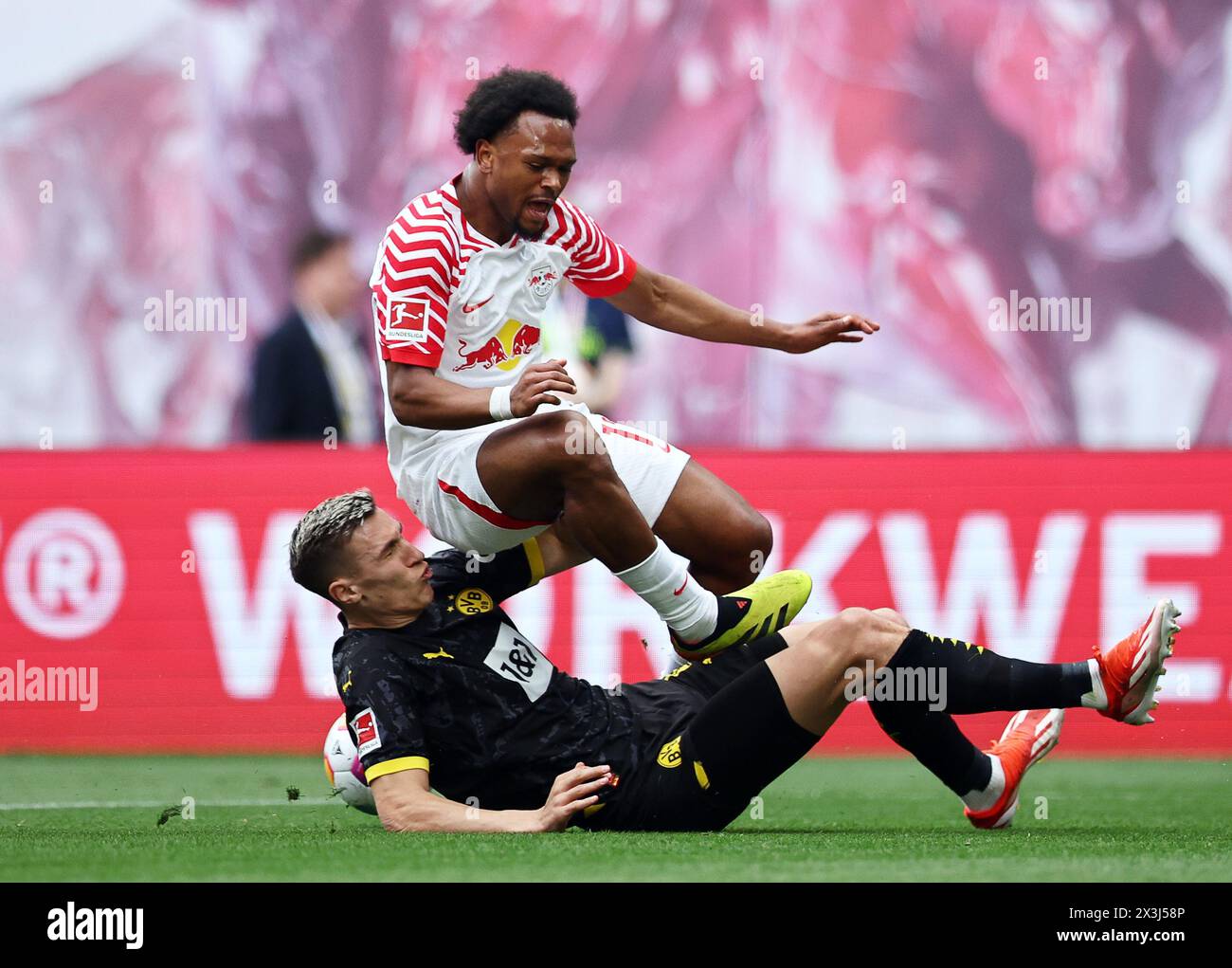 Leipzig, Germany. 27th Apr, 2024. Soccer: Bundesliga, RB Leipzig - Borussia Dortmund, Matchday 31, Red Bull Arena. Dortmund's Nico Schlotterbeck (below) and Leipzig's Lois Openda fight for the ball. IMPORTANT NOTE: In accordance with the regulations of the DFL German Football League and the DFB German Football Association, it is prohibited to use or have used photographs taken in the stadium and/or of the match in the form of sequential images and/or video-like photo series. Credit: Jan Woitas/dpa/Alamy Live News Stock Photo