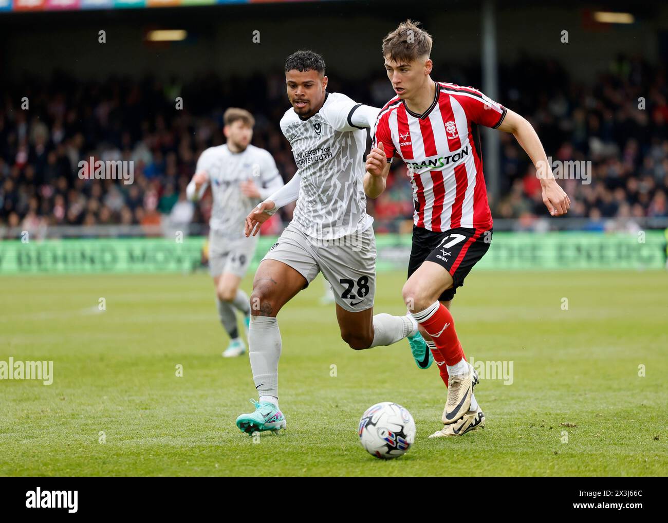 Lincoln City's Dylan Duffy and Portsmouth's Tino Anjorin in action ...