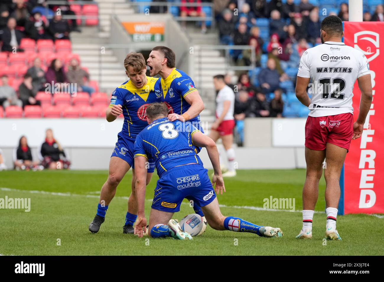 Leon Hayes of Warrington Wolves  and Danny Walker of Warrington Wolves celebrate with try scorer James Harrison of Warrington Wolves during the Betfred Super League Round 9 match Salford Red Devils vs Warrington Wolves at Salford Community Stadium, Eccles, United Kingdom, 27th April 2024  (Photo by Steve Flynn/News Images) Stock Photo