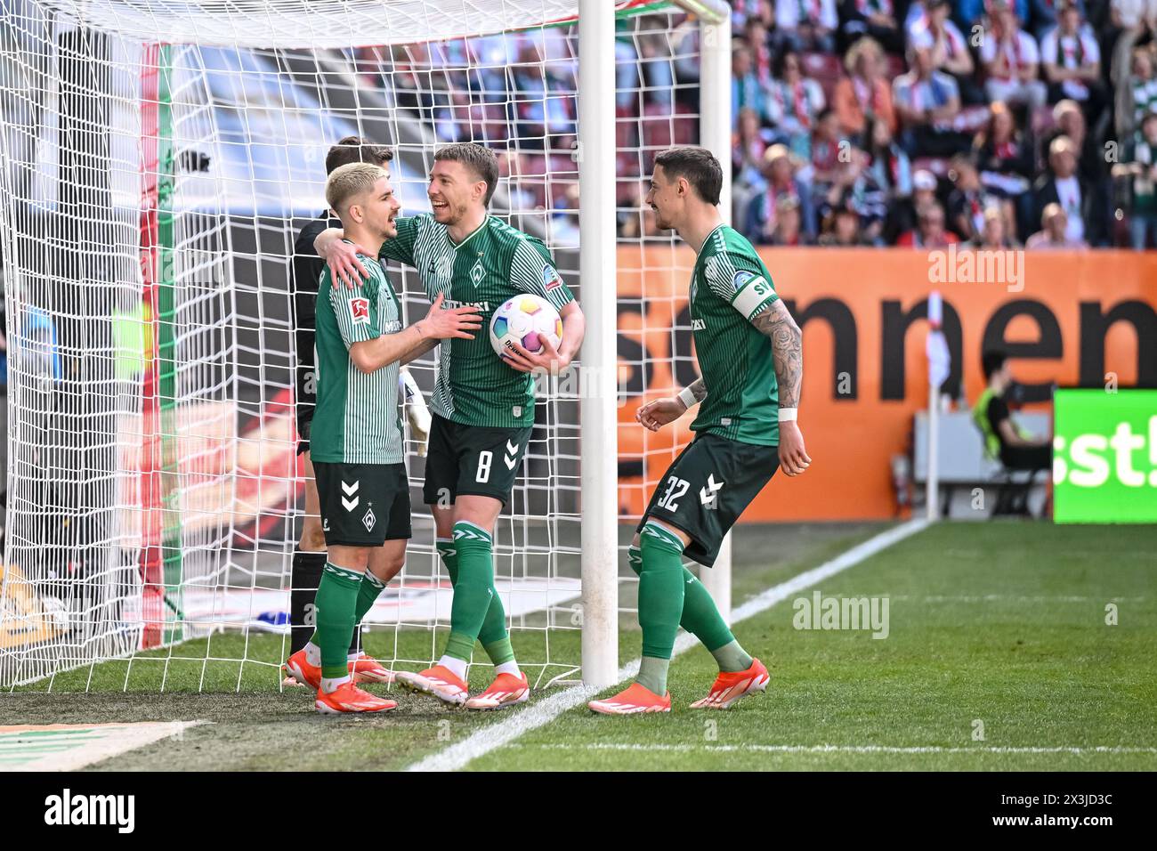 Augsburg, Germany. 27th Apr, 2024. Soccer: Bundesliga, FC Augsburg - Werder Bremen, Matchday 31, WWK-Arena. Bremen's Romano Schmid (l) Bremen's Mitchell Weiser (M) and Bremen's Marco Friedelr (r) celebrate after scoring the 0:2 goal. Credit: Harry Langer/dpa - IMPORTANT NOTE: In accordance with the regulations of the DFL German Football League and the DFB German Football Association, it is prohibited to utilize or have utilized photographs taken in the stadium and/or of the match in the form of sequential images and/or video-like photo series./dpa/Alamy Live News Stock Photo