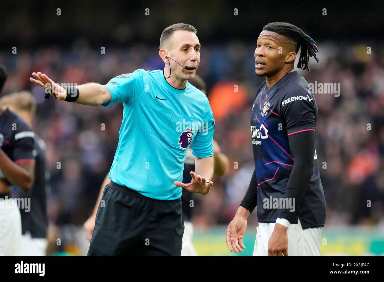 Match referee David Coote (left) speaks with Luton Town's Gabriel Osho during the Premier League match at Molineux Stadium, Wolverhampton. Picture date: Saturday April 27, 2024. Stock Photo