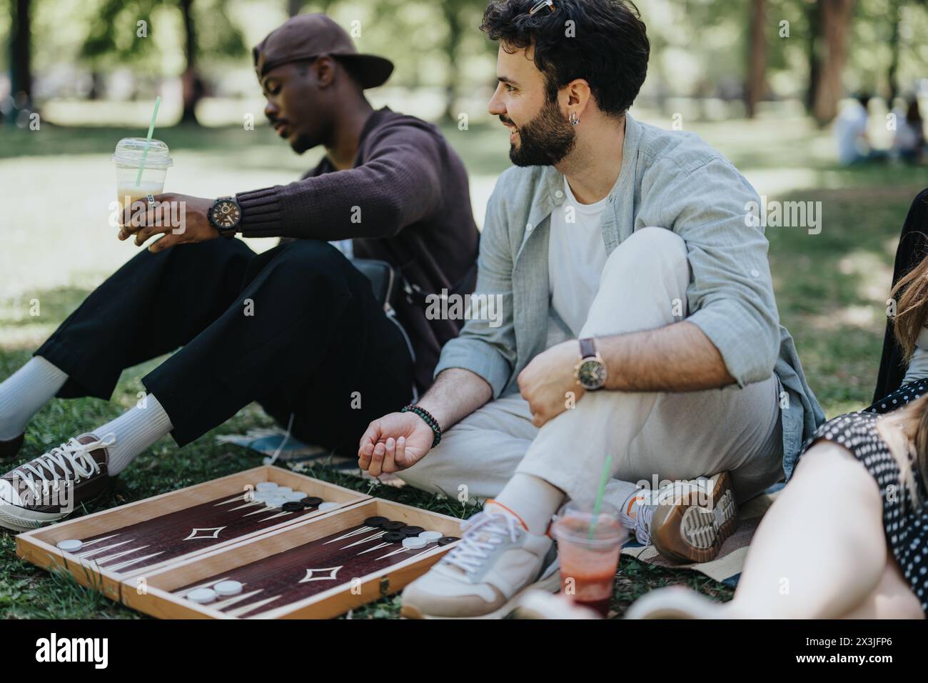 Multiracial friends enjoying a sunny day in the park, playing ...