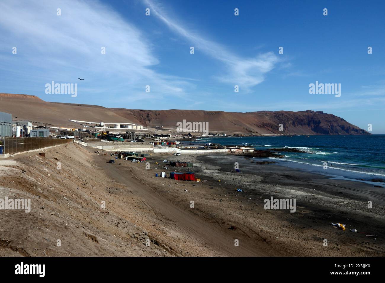 Temporary camps for squatters / homeless / immigrants on Playa Arenillas Negras beach next to Corpesca S.A. fish processing plant, near Arica, Chile Stock Photo