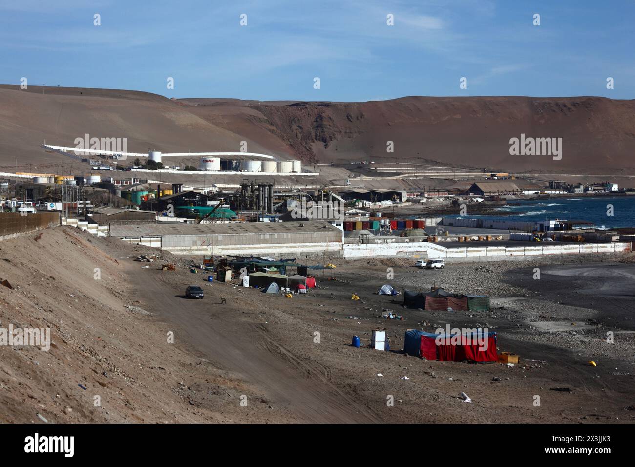 Temporary camps for squatters / homeless / immigrants on Playa Arenillas Negras beach next to Corpesca S.A. fish processing plant, near Arica, Chile Stock Photo