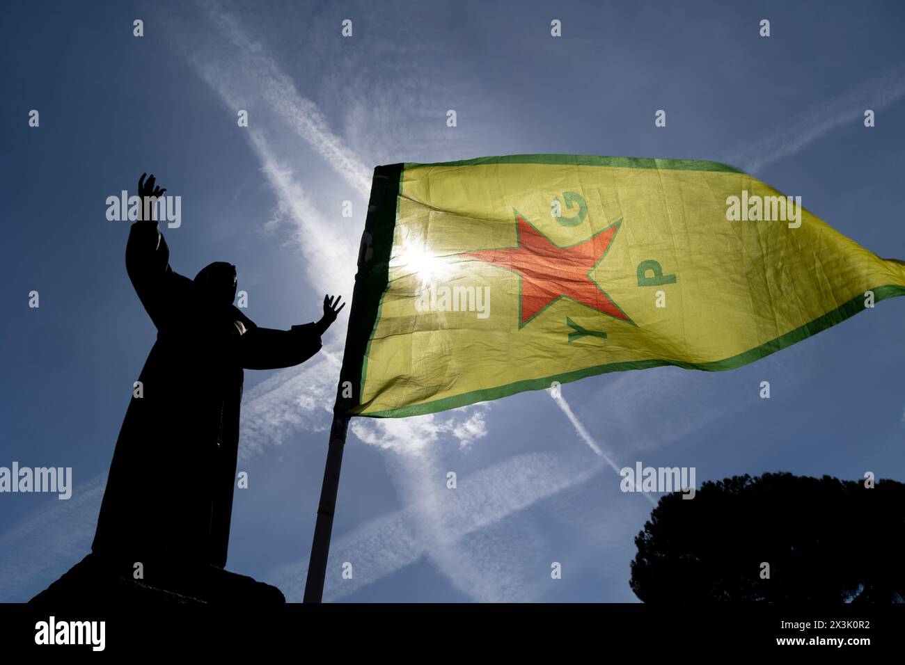 Rome, Italy. 27th Apr, 2024. Kurdish flag of YPG Popular Protection Unit flies in front of the statue of Saint Francis of Assisi in Piazza San Giovanni in Rome (Credit Image: © Matteo Nardone/Pacific Press via ZUMA Press Wire) EDITORIAL USAGE ONLY! Not for Commercial USAGE! Stock Photo