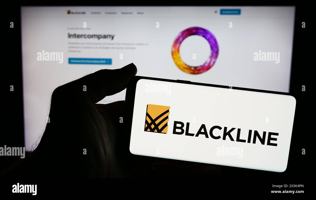 Person holding smartphone with logo of US enterprise software company BlackLine Systems Inc. in front of website. Focus on phone display. Stock Photo