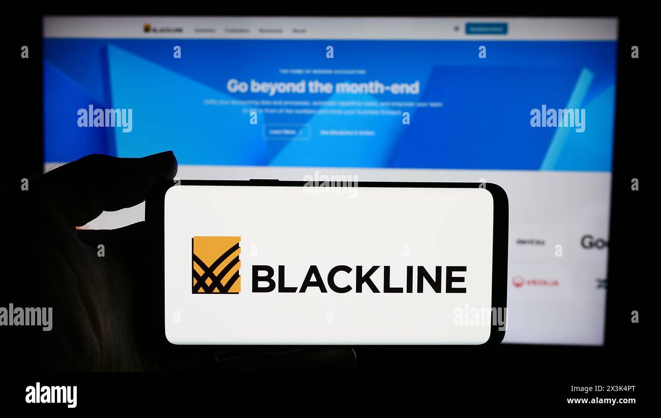 Person holding cellphone with logo of US enterprise software company BlackLine Systems Inc. in front of business webpage. Focus on phone display. Stock Photo