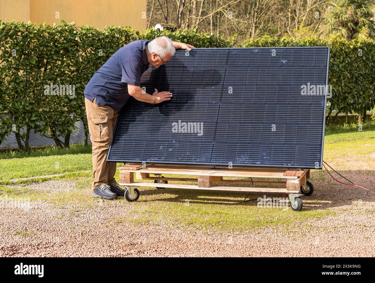 Senior man with photovoltaic solar panel in the garden. Stock Photo