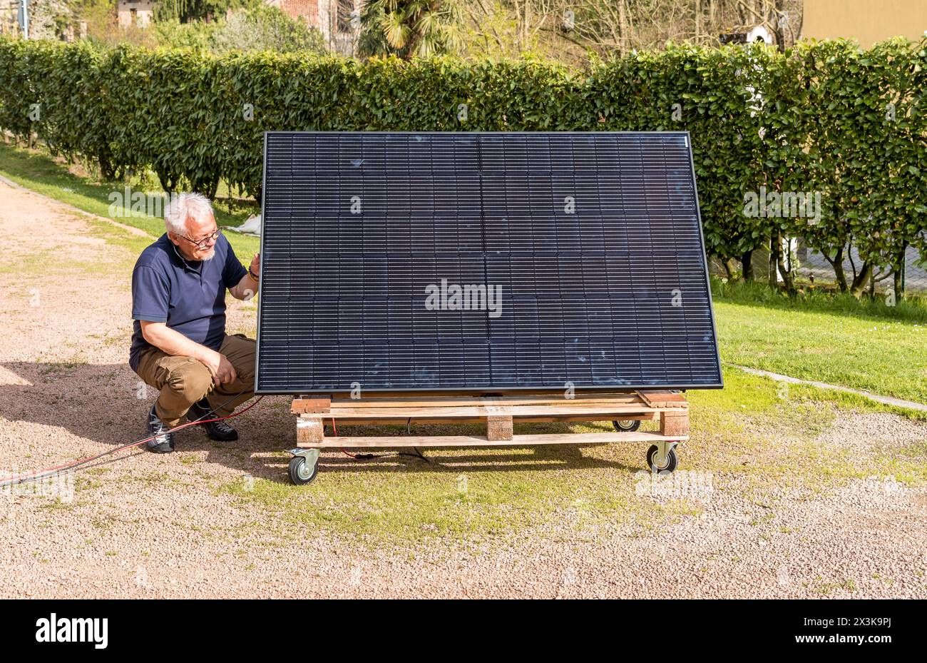 Senior man with photovoltaic solar panel in the garden. Stock Photo