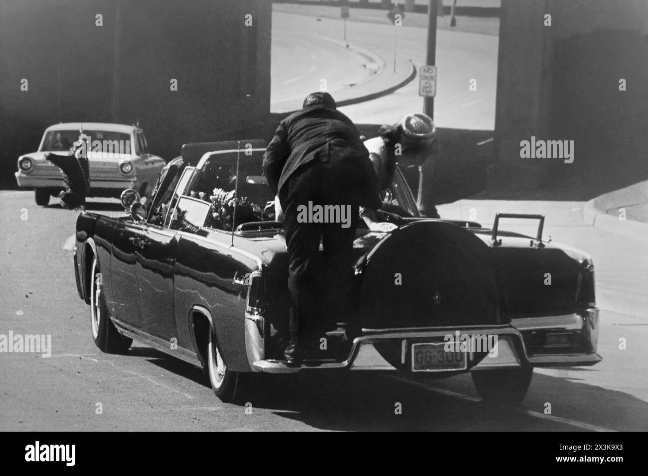 President John F. Kennedy slumped down in the back seat of his motorcade car after being shot in Dallas, Texas, on November 22, 1963. First Lady Jaqueline Kennedy leans over the President as a Secret Service man goes to her aid. (USA) Stock Photo