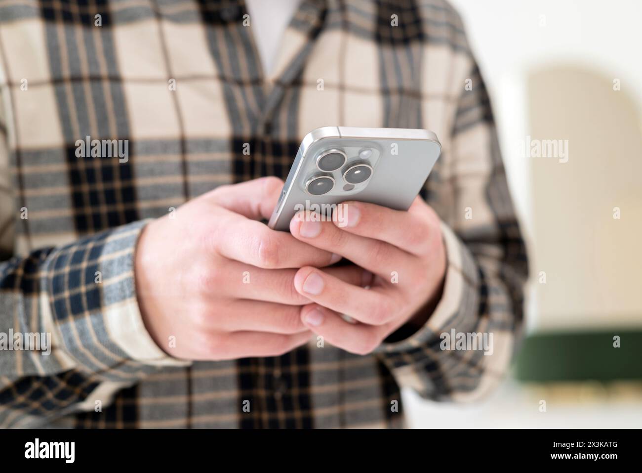 Kyiv, Ukraine. April 25, 2024. Man using a new mobile phone, iphone 15 smartphone close-up, holding cellphone in hands. texting message, scrolling. Stock Photo