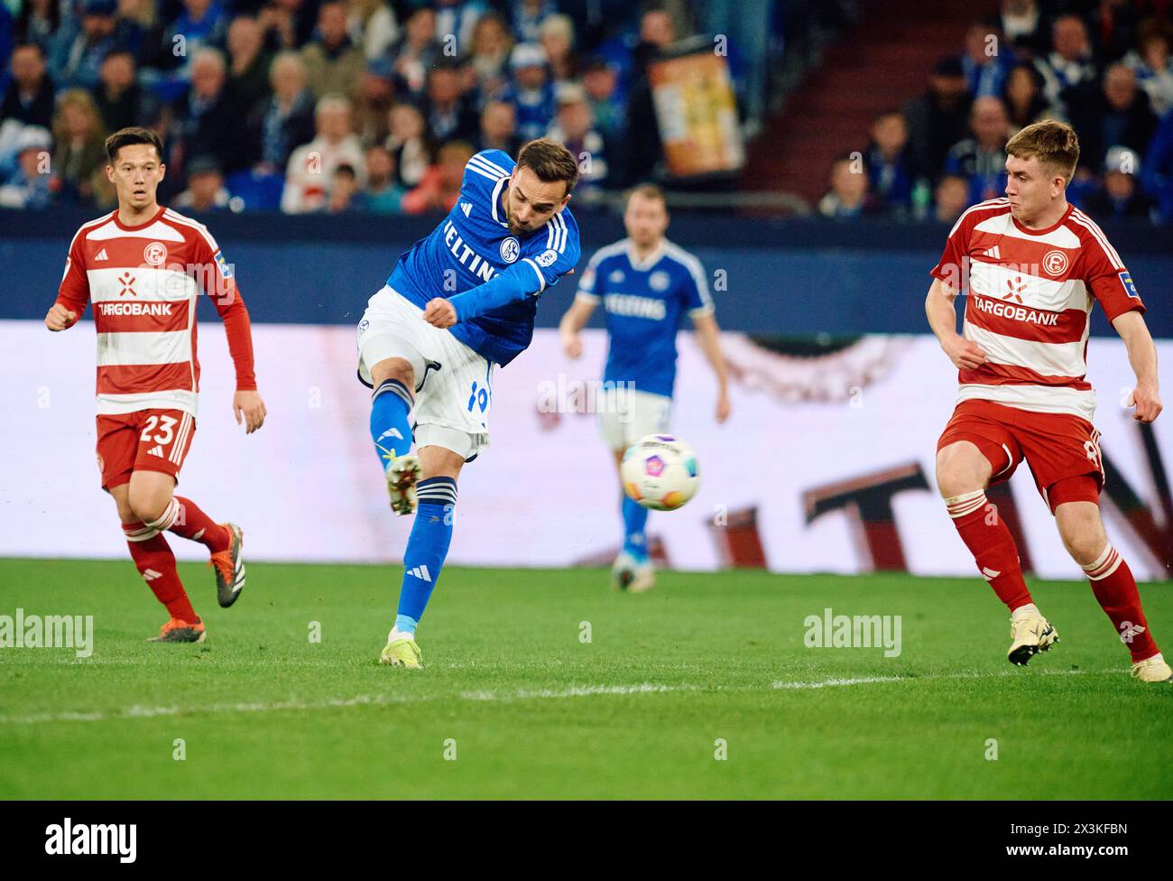 27 April 2024, North Rhine-Westphalia, Gelsenkirchen: Soccer: Bundesliga 2, FC Schalke 04 - Fortuna Düsseldorf, matchday 31 at the Veltins Arena. Schalke's Kenan Karaman (center) scores his goal to make it 1-0. Shinta Appelkamp on the left, Isak Johannesson of Düsseldorf on the right Photo: Bernd Thissen/dpa - IMPORTANT NOTE: In accordance with the regulations of the DFL German Football League and the DFB German Football Association, it is prohibited to utilize or have utilized photographs taken in the stadium and/or of the match in the form of sequential images and/or video-like photo series. Stock Photo