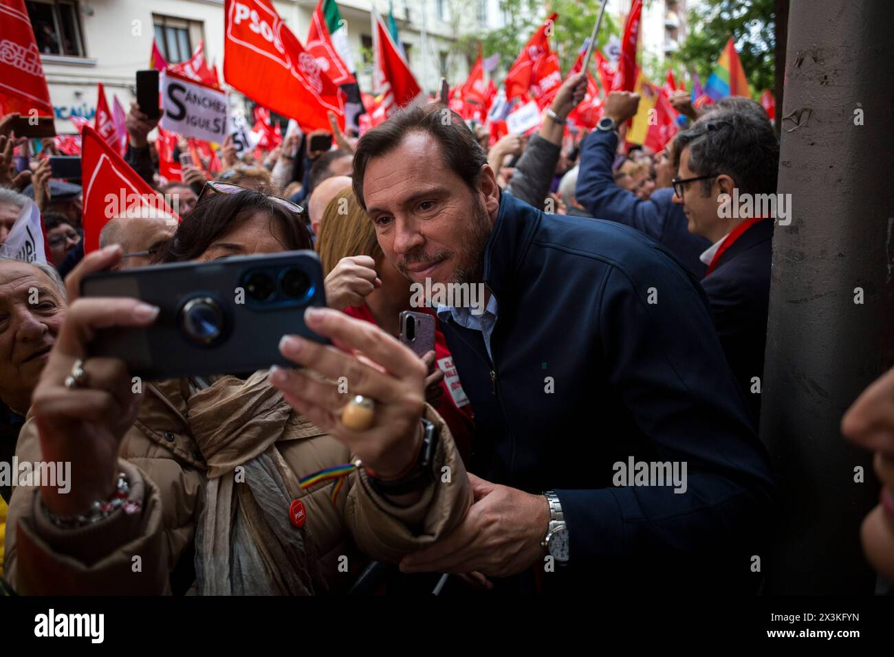 A protester takes a selfie with Oscar Puente, Minister of Transport and Sustainable Mobility of Spain, during a demonstration on Ferraz Street in Madrid, in support of Pedro Sanchez to continue in the position of president of the government. Pedro Sanchez, canceled his public agenda for four days and reflects on his continuity as head of the Executive. The Federal Committee of the Spanish Socialist Workers Party (PSOE) held a meeting and demonstrated at the national headquarters on Ferraz Street in Madrid to show support for the party's general secretary and president of the Government of Spai Stock Photo