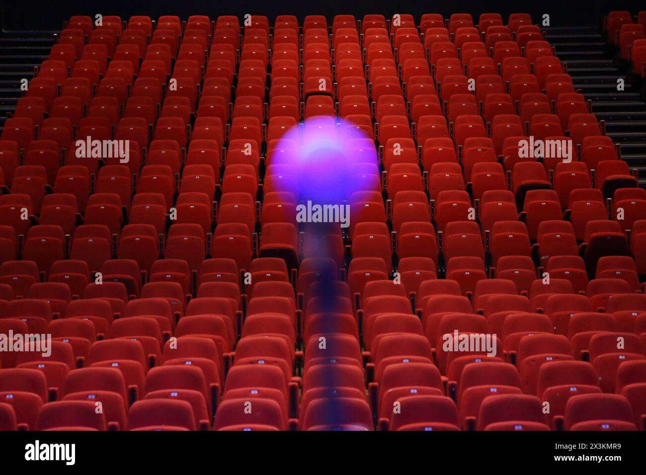 Microphone with red seats in auditorium in background - conept public speaking fear of public speaking performing in the spotlight Stock Photo
