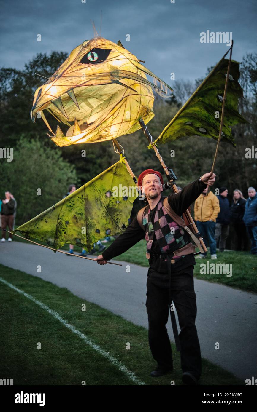 A paper puppet dragon lantern carried by a man in Roberts Park, Saltaire during a lantern parade for World Heritage Day. Stock Photo