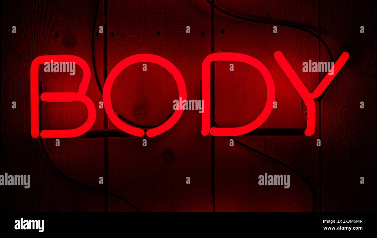 Four neon letter for the word body. Red electric light on wooden background Stock Photo
