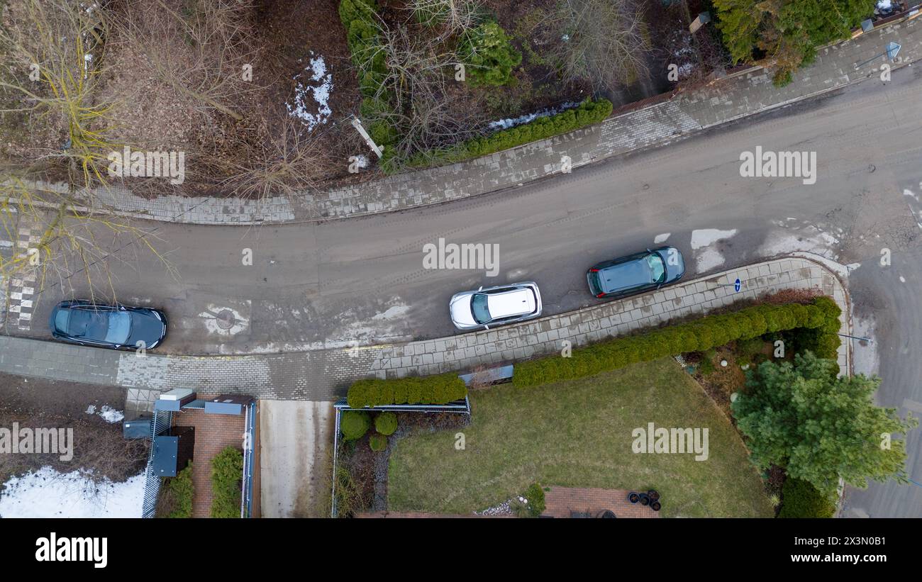 Drone photography of houses and parked cars on a street in a city ...