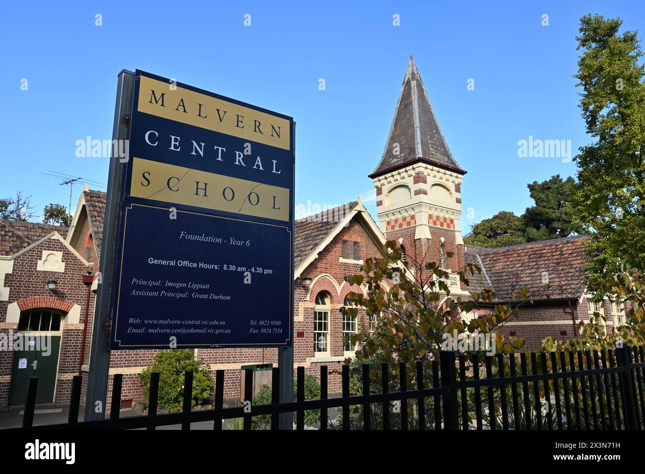 Blue and yellow sign outside the historical Malvern Central School, previously Spring Road School, featuring school contact information Stock Photo
