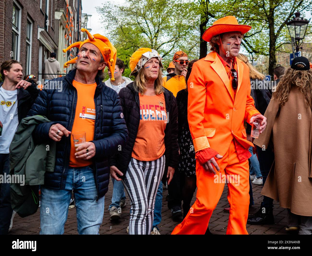 Amsterdam, Netherlands. 27th Apr, 2024. A group of people are seen wearing orange clothes. King's Day is renowned for being one of the biggest and most colorful festivities in the country, especially in Amsterdam. The city is bursting with orange as people enjoy the biggest street party of the year, enjoying the free markets and having fun on the boats along the canals. Credit: SOPA Images Limited/Alamy Live News Stock Photo