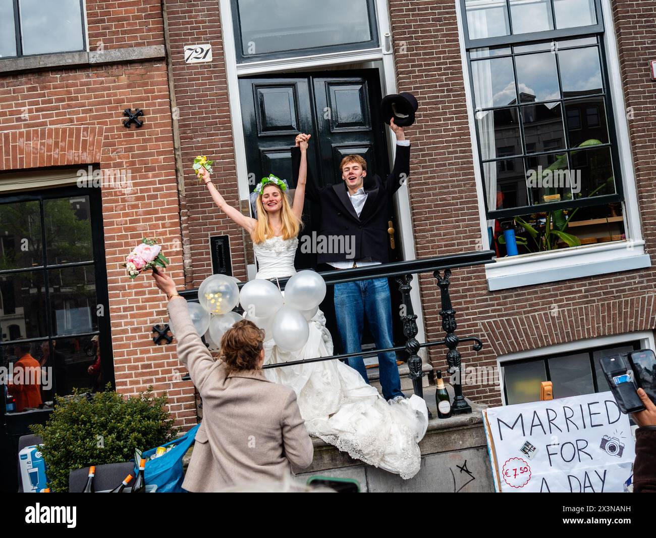 Amsterdam, Netherlands. 27th Apr, 2024. A couple is seen getting a fake marriage. King's Day is renowned for being one of the biggest and most colorful festivities in the country, especially in Amsterdam. The city is bursting with orange as people enjoy the biggest street party of the year, enjoying the free markets and having fun on the boats along the canals. Credit: SOPA Images Limited/Alamy Live News Stock Photo