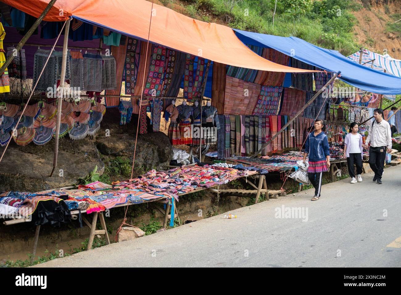 Colourful traditional clothing and items for sale at Can Cau Market in Lao Cai Province, Vietnam Stock Photo