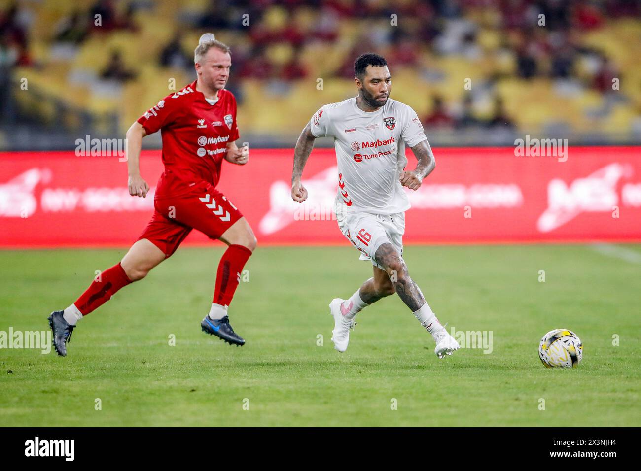 Kuala Lumpur, Malaysia. 27th Apr, 2024. Erik Nevland of Manchester Reds (L) and Jermaine Pennant of Liverpool Reds (R) seen in action during the 'Battle of the Reds 2024' match between Manchester United and Liverpool legends at National Stadium Bukit Jalil. Final score; Liverpool Reds 4:2 Manchester Reds. Credit: SOPA Images Limited/Alamy Live News Stock Photo