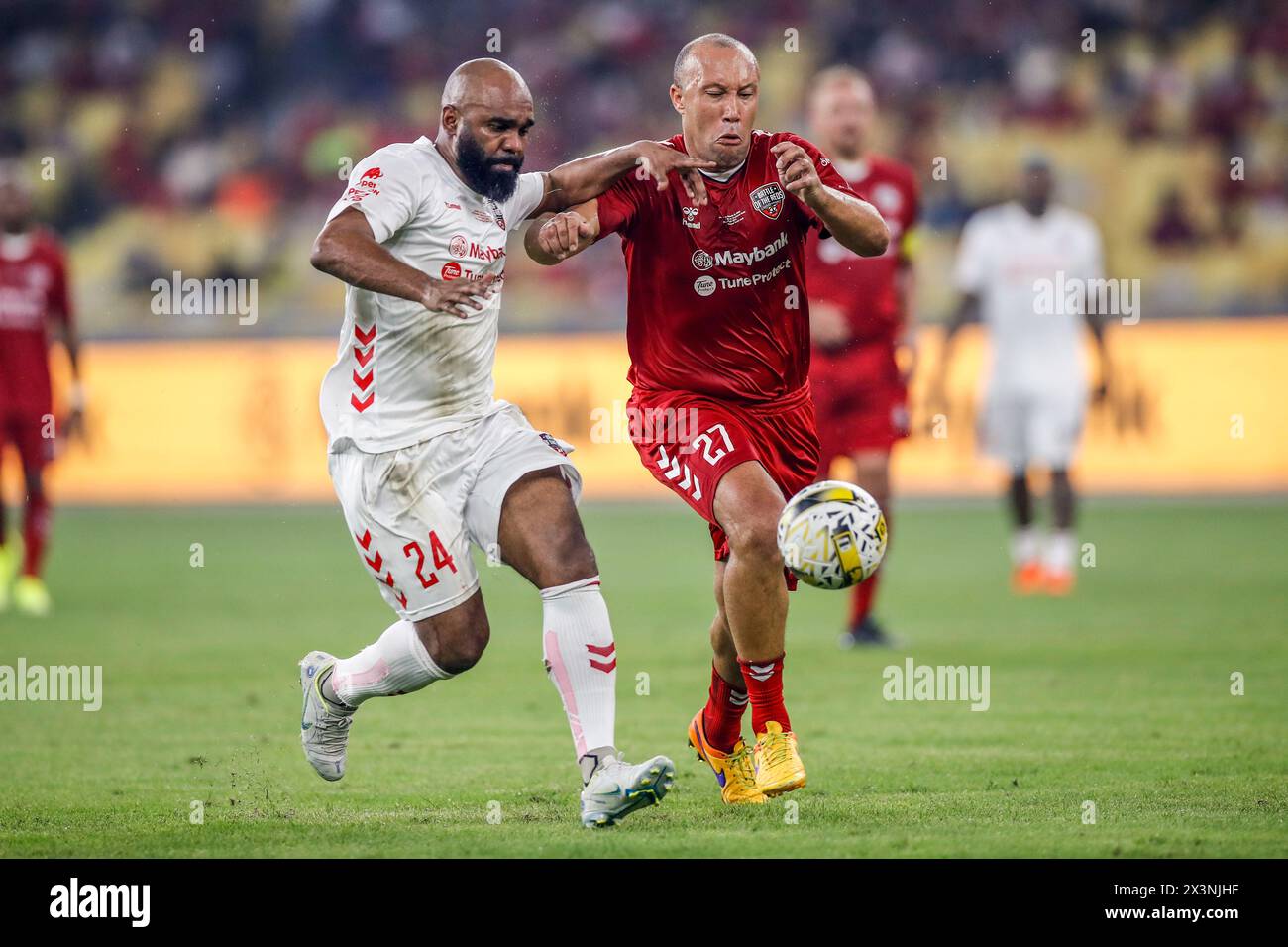 Kuala Lumpur, Malaysia. 27th Apr, 2024. Florent Sinama of Liverpool Reds (L) and Mikael Silvestre of Manchester Reds (R) seen in action during the 'Battle of the Reds 2024' match between Manchester United and Liverpool legends at National Stadium Bukit Jalil. Final score; Liverpool Reds 4:2 Manchester Reds. Credit: SOPA Images Limited/Alamy Live News Stock Photo