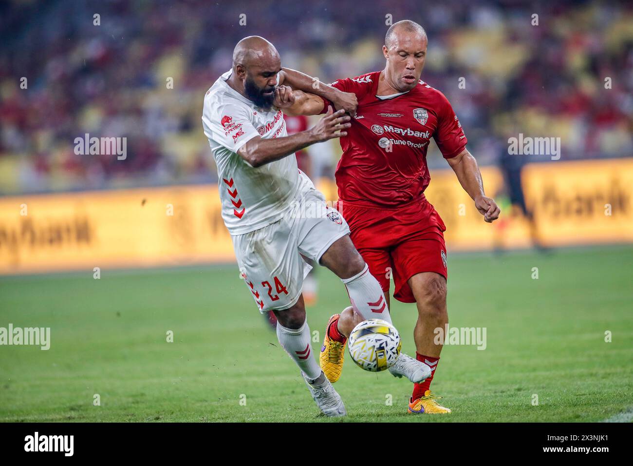 Kuala Lumpur, Malaysia. 27th Apr, 2024. Florent Sinama of Liverpool Reds (L) and Mikael Silvestre of Manchester Reds (R) seen in action during the 'Battle of the Reds 2024' match between Manchester United and Liverpool legends at National Stadium Bukit Jalil. Final score; Liverpool Reds 4:2 Manchester Reds. Credit: SOPA Images Limited/Alamy Live News Stock Photo