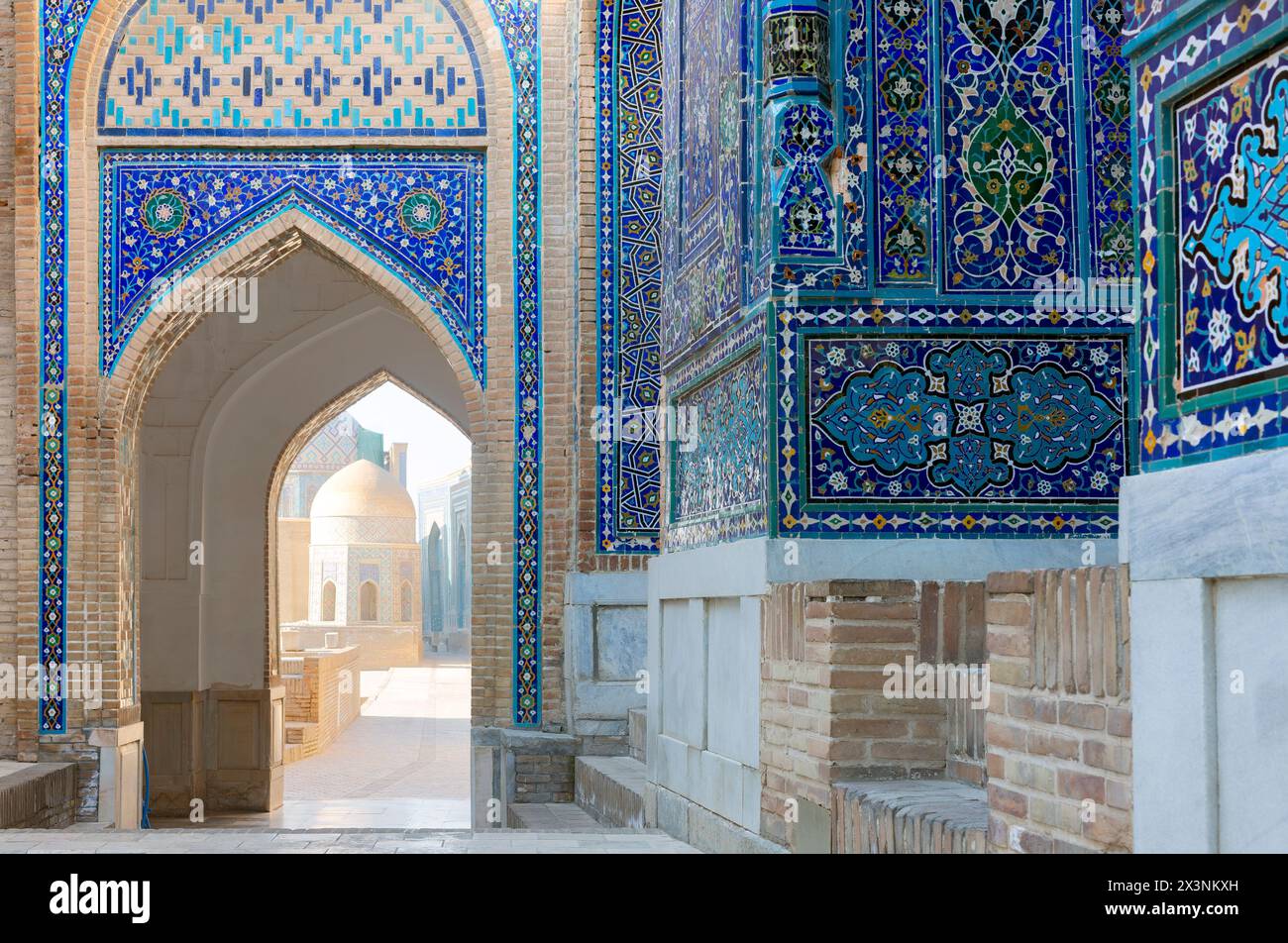 View of the mausoleums and domes of the historic Shahi Zinda cemetery through an arched gate, Samarkand, Uzbekistan. Stock Photo