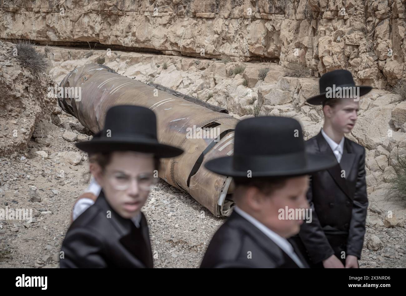 Arad, Israel. 28th Apr, 2024. Israeli Orthodox Jews inspect parts of an Iranian rocket that were left in the desert near southern Israeli city of Arad. Credit: Ilia Yefimovich/dpa/Alamy Live News Stock Photo