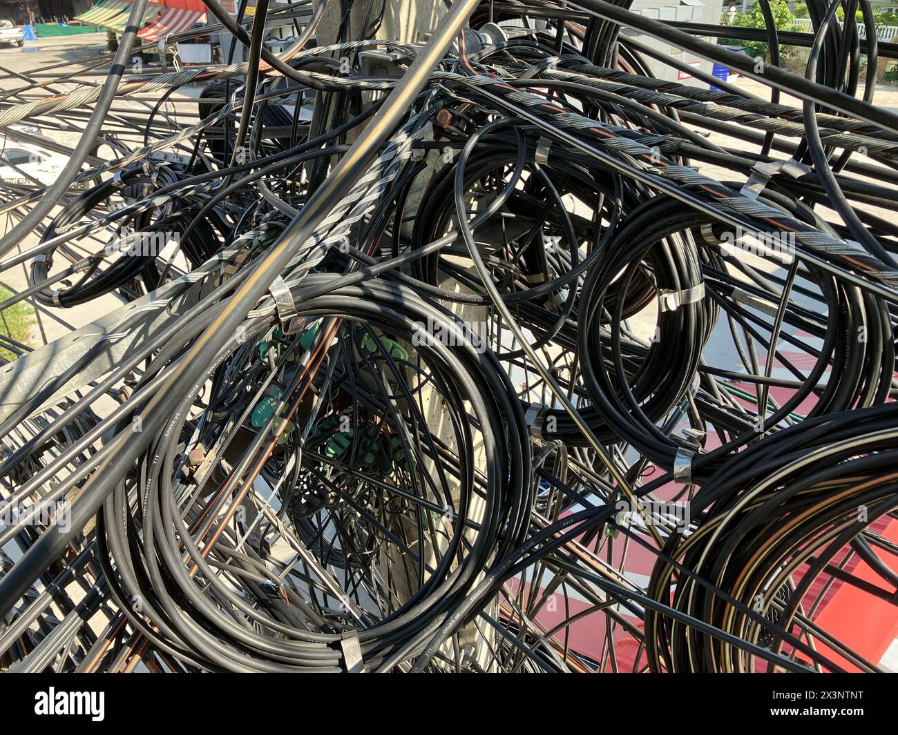 Close-up of cables and electrical wires hanging on the concrete pole. Stock Photo