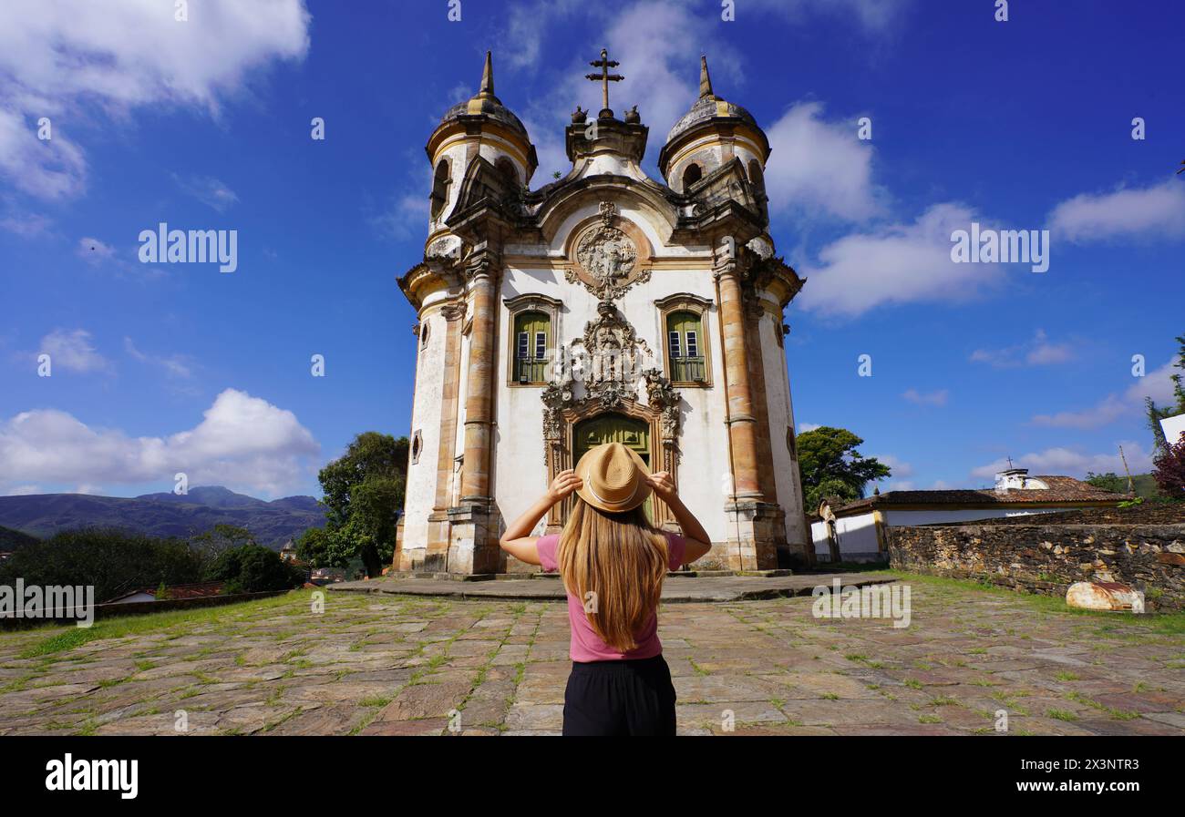 Tourism in Ouro Preto, Brazil. Back view of young tourist woman in Ouro Preto visiting Saint Francis of Assisi church in Minas Gerais state, Brazil. U Stock Photo