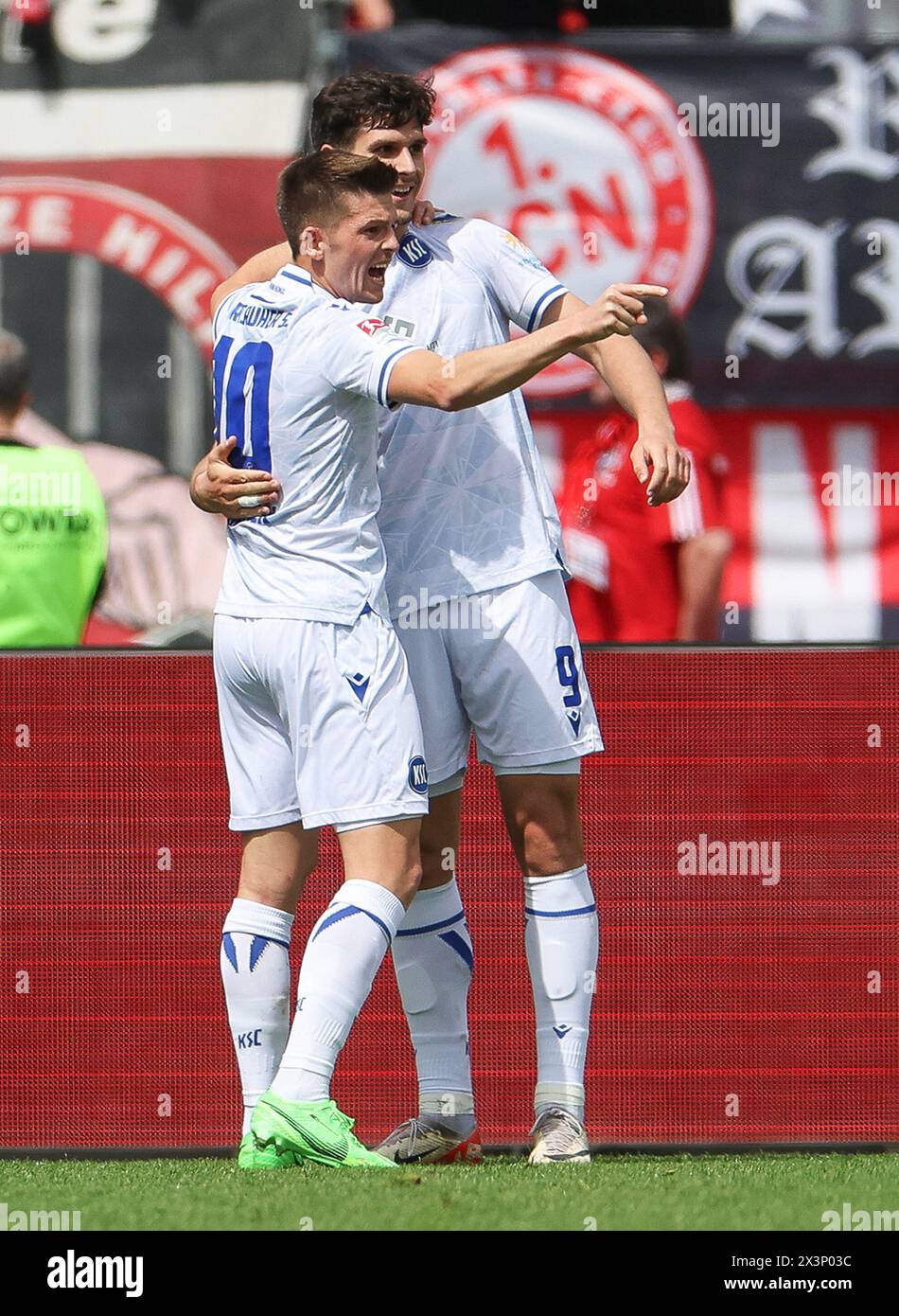 Nuremberg, Germany. 28th Apr, 2024. Soccer: Bundesliga 2, 1. FC Nürnberg - Karlsruher SC, Matchday 31, Max-Morlock-Stadion. Karlsruhe's Igor Matanovic (r) celebrates his 1:0 goal with teammate Marvin Wanitzek. Credit: Daniel Löb/dpa - IMPORTANT NOTE: In accordance with the regulations of the DFL German Football League and the DFB German Football Association, it is prohibited to utilize or have utilized photographs taken in the stadium and/or of the match in the form of sequential images and/or video-like photo series./dpa/Alamy Live News Stock Photo