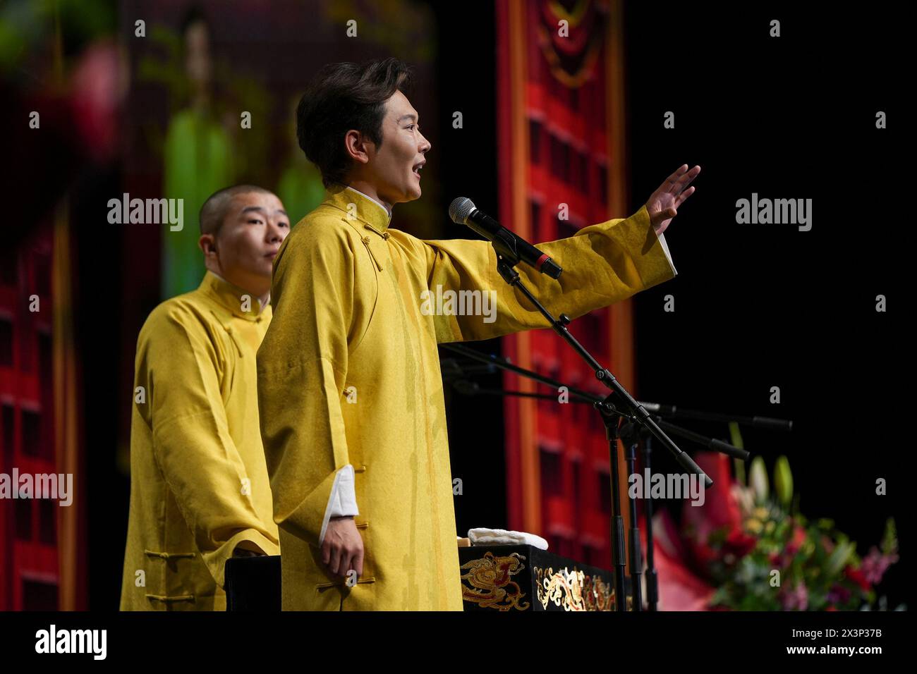 (240428) -- LONDON, April 28, 2024 (Xinhua) -- Meng Hetang (R) and Zhou Jiuliang perform Xiangsheng, or crosstalk comedy in London, Britain, April 27, 2024. Thunderous laughter and applause almost blew off the roof of an auditorium in London's ExCeL Exhibition Centre on Saturday night, when a punchline by Guo Degang, a popular Chinese traditional crosstalk comedian, landed with an audience of thousands. Along with Guo and his partner Yu Qian, a handful of comedians from the De Yun She Performance Group performed Xiangsheng, or crosstalk comedy, with both jokes about life anecdotes and tradi Stock Photo