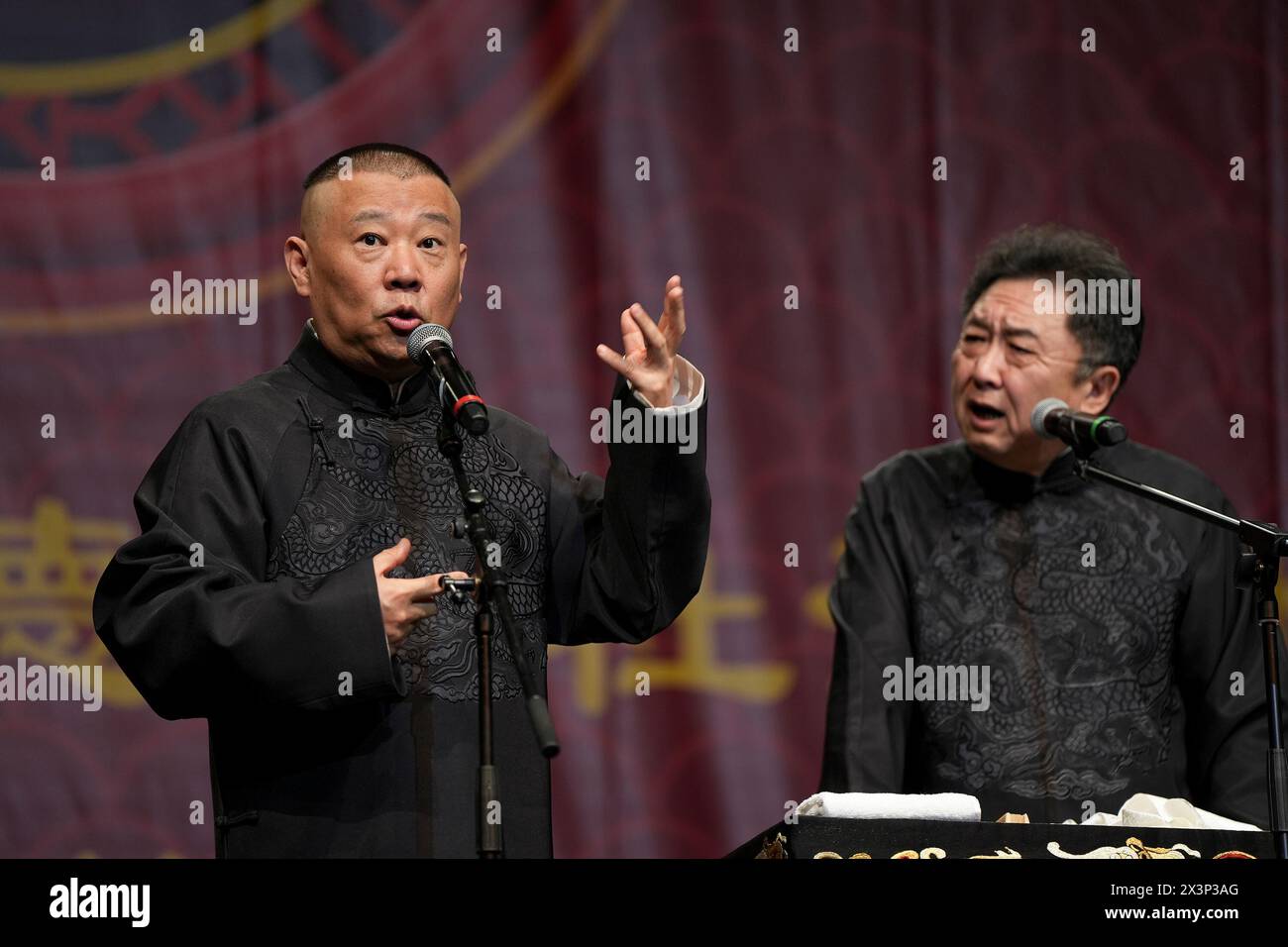 (240428) -- LONDON, April 28, 2024 (Xinhua) -- Guo Degang (L) and Yu Qian perform Xiangsheng, or crosstalk comedy in London, Britain, April 27, 2024.  Thunderous laughter and applause almost blew off the roof of an auditorium in London's ExCeL Exhibition Centre on Saturday night, when a punchline by Guo Degang, a popular Chinese traditional crosstalk comedian, landed with an audience of thousands.   Along with Guo and his partner Yu Qian, a handful of comedians from the De Yun She Performance Group performed Xiangsheng, or crosstalk comedy, with both jokes about life anecdotes and traditional Stock Photo