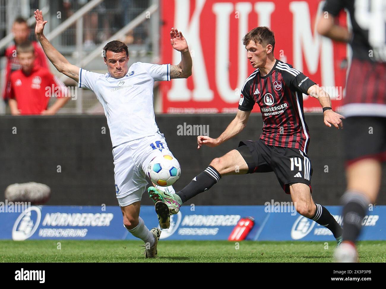 Nuremberg, Germany. 28th Apr, 2024. Soccer: Bundesliga 2, 1. FC Nürnberg - Karlsruher SC, Matchday 31, Max-Morlock-Stadion. Karlsruhe's Marvin Wanitzek (l) and Nuremberg's Benjamin Goller in action. Credit: Daniel Löb/dpa - IMPORTANT NOTE: In accordance with the regulations of the DFL German Football League and the DFB German Football Association, it is prohibited to utilize or have utilized photographs taken in the stadium and/or of the match in the form of sequential images and/or video-like photo series./dpa/Alamy Live News Stock Photo