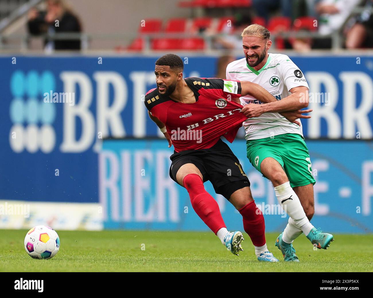 Wiesbaden, Germany. 28th Apr, 2024. Soccer: Bundesliga 2, SV Wehen Wiesbaden - SpVgg Greuther Fürth, Matchday 31, BRITA-Arena. Wiesbaden's Keanan Bennetts (l) and Fürth's Simon Asta fight for the ball. Credit: Jörg Halisch/dpa - IMPORTANT NOTE: In accordance with the regulations of the DFL German Football League and the DFB German Football Association, it is prohibited to utilize or have utilized photographs taken in the stadium and/or of the match in the form of sequential images and/or video-like photo series./dpa/Alamy Live News Stock Photo