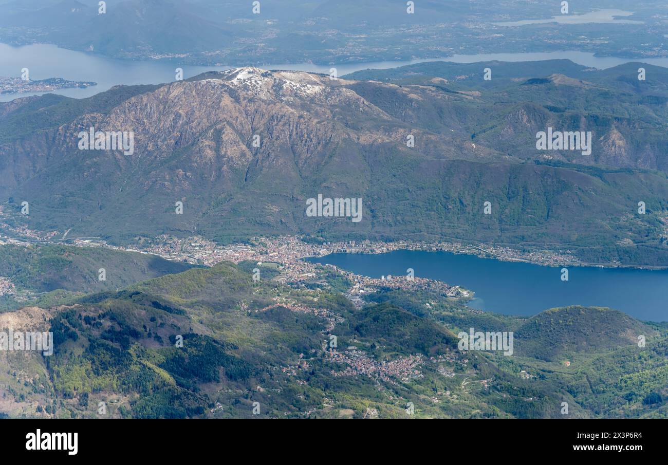 aerial landscape, from a glider plane, with Omegna town on Orta lake, shot from west in bright cloudy light, Piedmont, Italy Stock Photo