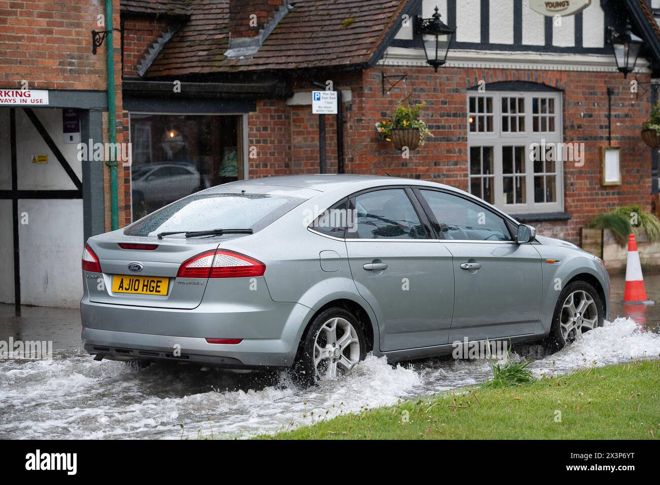 Chalfont St Giles, Buckinghamshire, UK. 28th April, 2024. Motorists driving through floodwater. Parts of the village of Chalfont St Giles in Buckinghamshire was flooded again today after heavy overnight rain. There are ongoing issues with groundwater flooding across the Chalfonts. Credit: Maureen McLean/Alamy Live News Stock Photo