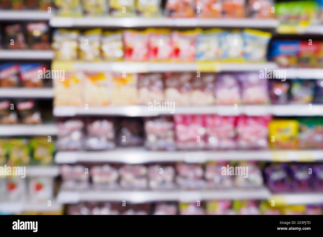 Abstract blur supermarket with variety of fast food snacks chips product on the shelves in store defocused background Stock Photo