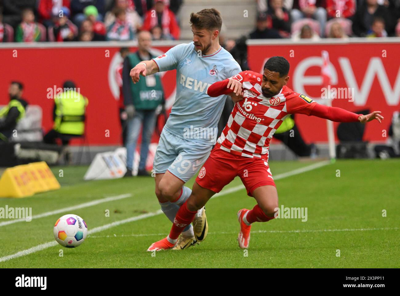 Mainz, Germany. 28th Apr, 2024. Soccer: Bundesliga, FSV Mainz 05 - 1. FC Köln, Matchday 31, Mewa Arena. Mainz's Phillip Mwene (r) in action against Cologne's Jan Thielmann. Credit: Torsten Silz/dpa - IMPORTANT NOTE: In accordance with the regulations of the DFL German Football League and the DFB German Football Association, it is prohibited to utilize or have utilized photographs taken in the stadium and/or of the match in the form of sequential images and/or video-like photo series./dpa/Alamy Live News Stock Photo